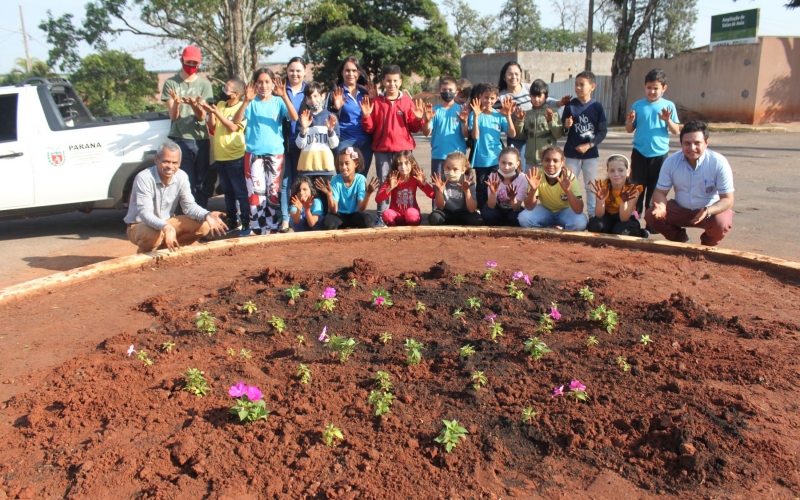 Alunos e professores da Escola Municipal Manoel Ribas realizaram plantio de flores e de grama em rotatória 